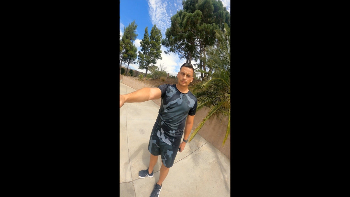 Man standing outside in camo athletic gear.