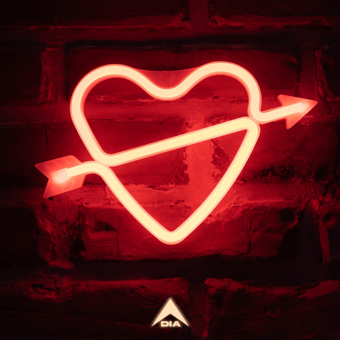 Red neon heart with an arrow on a dark brick wall, featuring a white DIA logo.