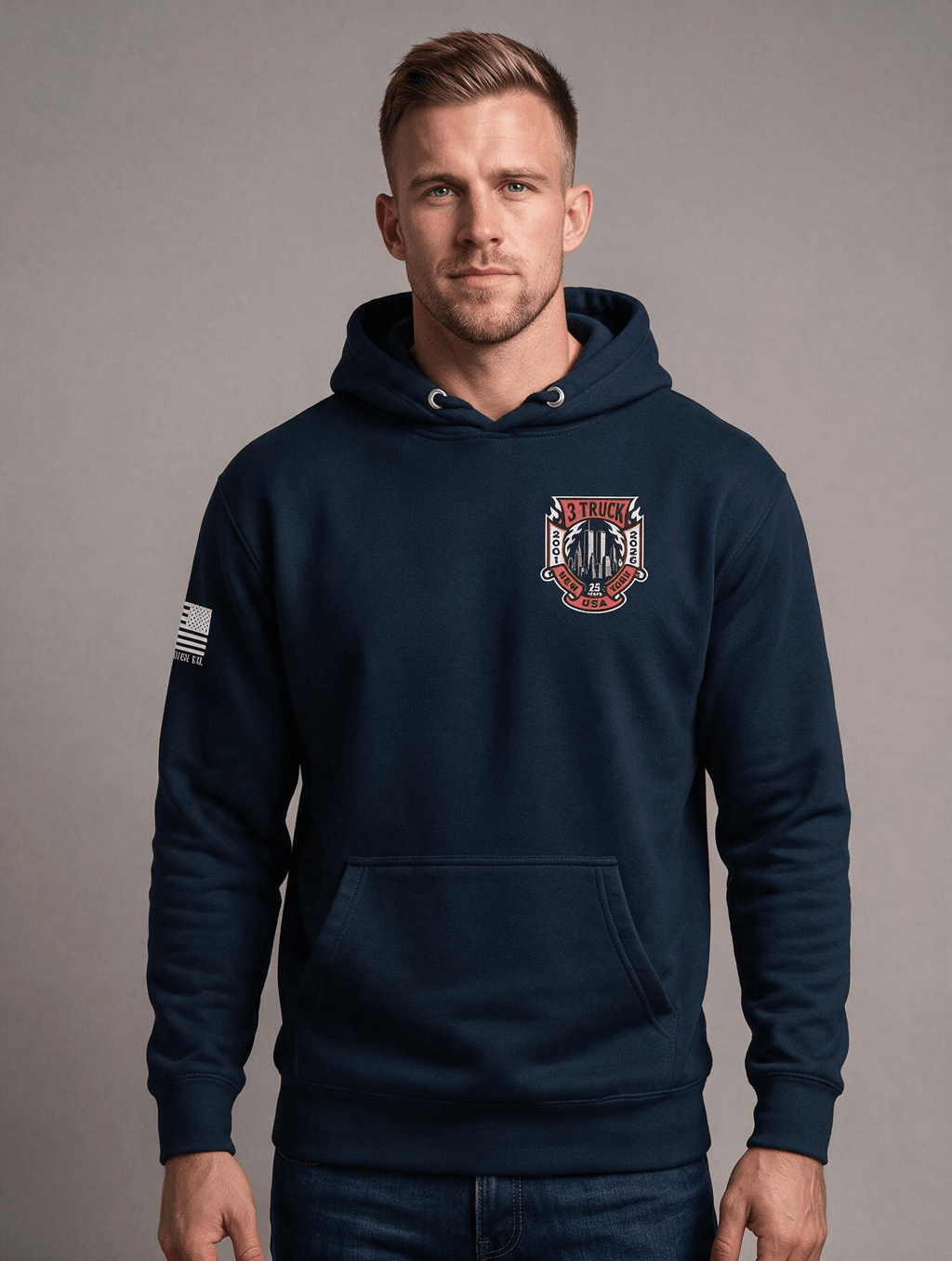 Man in studio wearing navy hoodie with 3 Truck 9/11 memorial chest graphic and American flag sleeve patch.