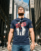 Man standing in a city street, wearing a navy firefighter "We're Still Heading Up" graphic t-shirt.
