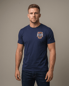 Man in studio wearing a navy T-shirt featuring a 3 Truck 9/11 memorial chest graphic and an American flag sleeve patch.