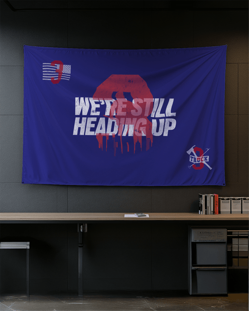 Modern office blue Truck 3 memorial flag with a red number 3, skyline, and firefighting tools on a dark wall.