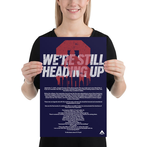 Woman holding a navy blue poster featuring "WE'RE STILL HEADING UP" text, red 3 graphic, and a DIA logo.