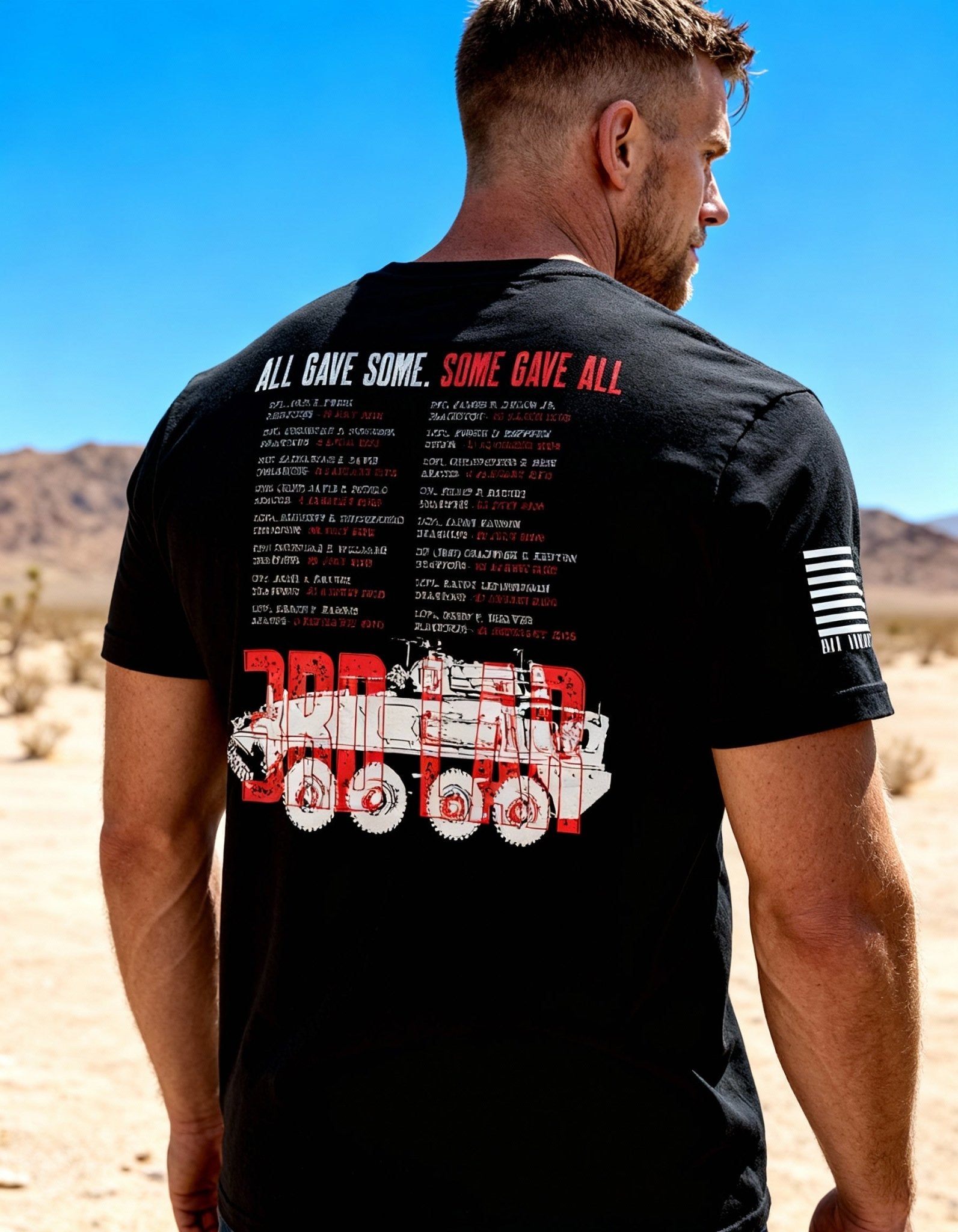 Man in a desert wearing a black t-shirt with a white armored vehicle and red "3RD LAR" text on the back.