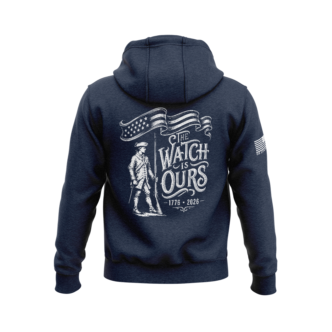 Navy hoodie featuring back graphic with a Minute Man soldier, "THE WATCH IS OURS 1776-2026" text, and American flag sleeve patch.