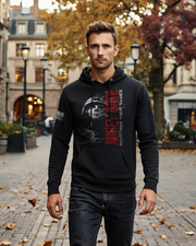 Man wearing black hoodie featuring "Abbey Gate Remember Their Names" design, walking in urban setting with autumn foliage.
