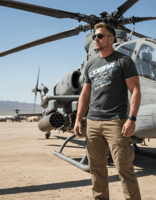Man by an AH-1 Cobra helicopter wearing a charcoal gray AH-1 Cobra t-shirt with "Death From Above!" text.