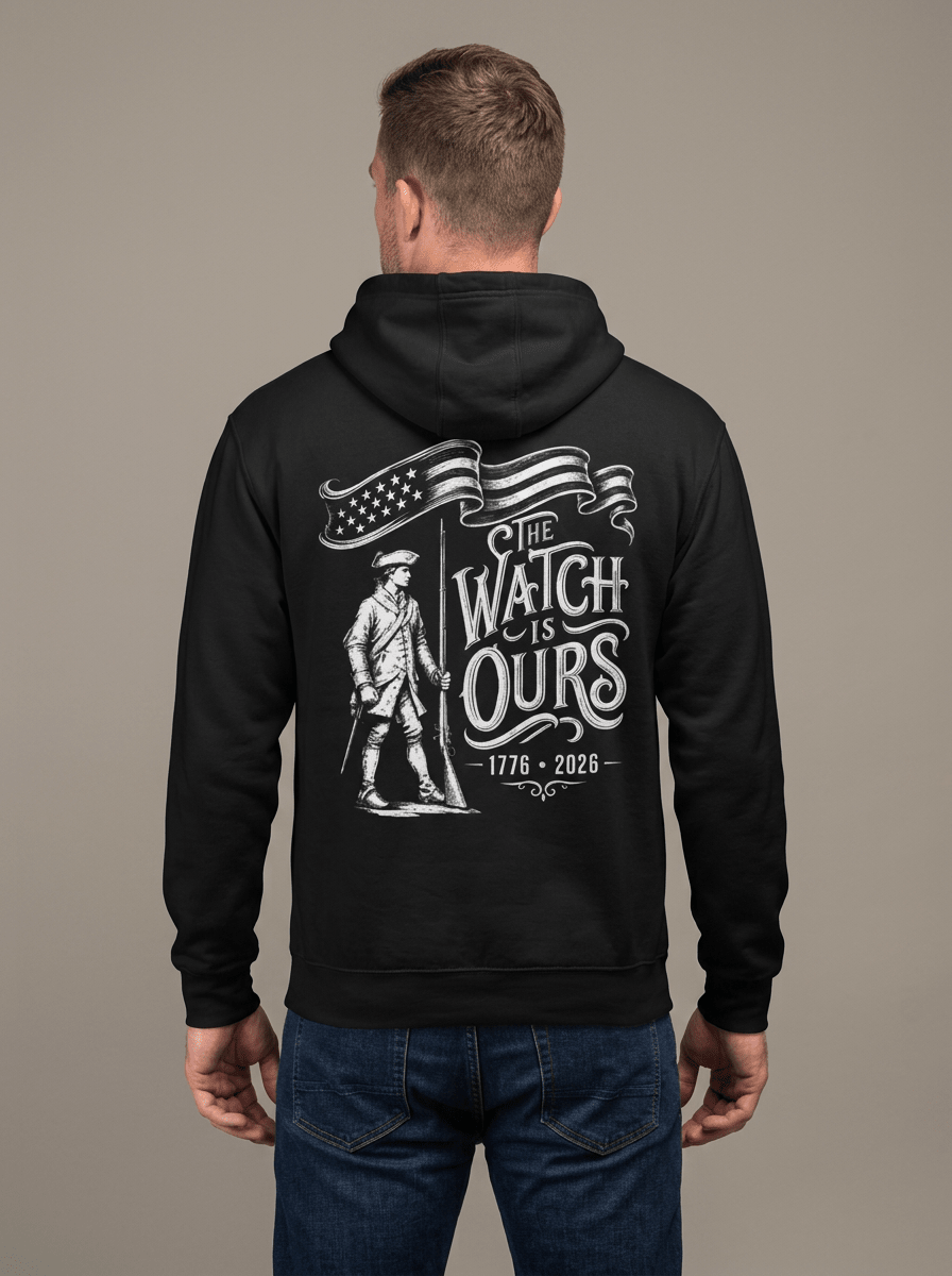 Man from behind in studio wearing black hoodie with "THE WATCH IS OURS 1776-2026" minuteman back graphic.