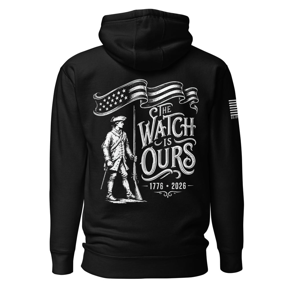 Black hoodie with "THE WATCH IS OURS 1776-2026" minuteman back graphic and American flag patch on sleeves.