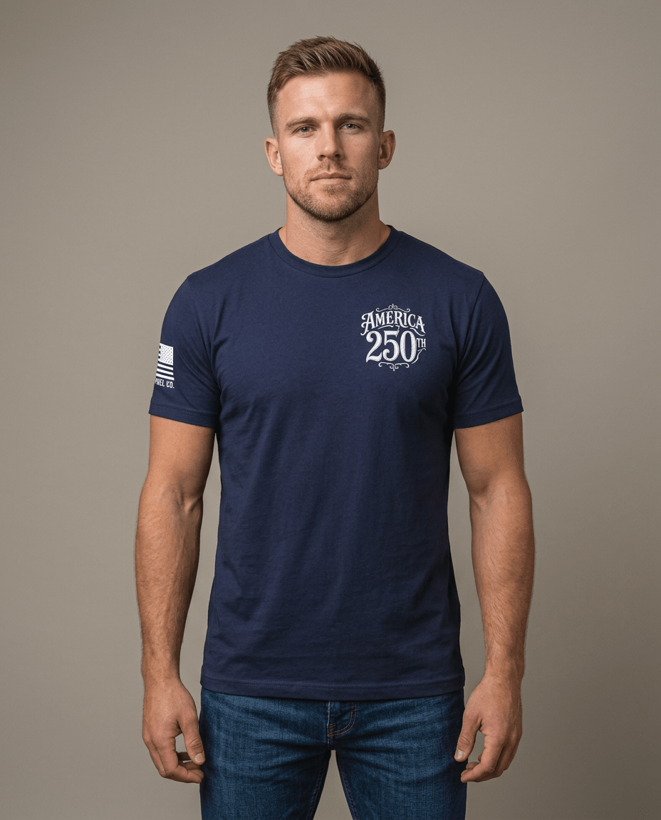 Man in studio wearing navy t-shirt featuring "AMERICA 250TH" chest graphic and American flag sleeve patch.