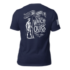 Navy t-shirt with "THE WATCH IS OURS 1776-2026" minuteman back graphic and American flag sleeve patch.