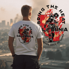 Man before smoky city skyline wearing white Bring the Heat t-shirt with red firefighter graphic and California silhouette
