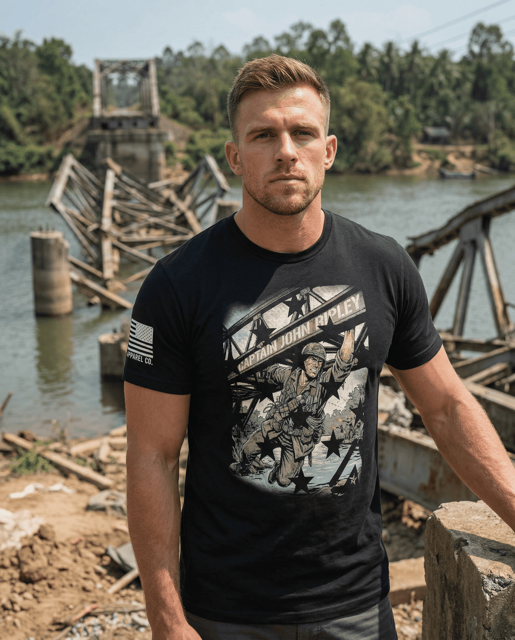 A man stands by a destroyed bridge, wearing a Captain John Ripley t-shirt with an American flag on the sleeve.