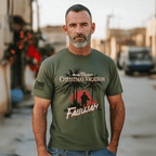 Man with a graying beard outdoors in a sunlit urban area wearing an army green Iraq 2004 Christmas t-shirt.