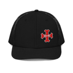 Black trucker hat front with red "DEUS VULT" cross logo and black mesh back.