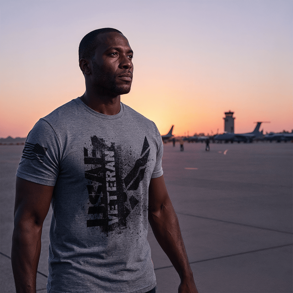 A man stands on an airfield at sunset, wearing a gray "USAF VETERAN" t-shirt with an American flag on the sleeve.