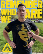 man in park wearing black t-shirt front with yellow snake graphic and American flag on sleeve.