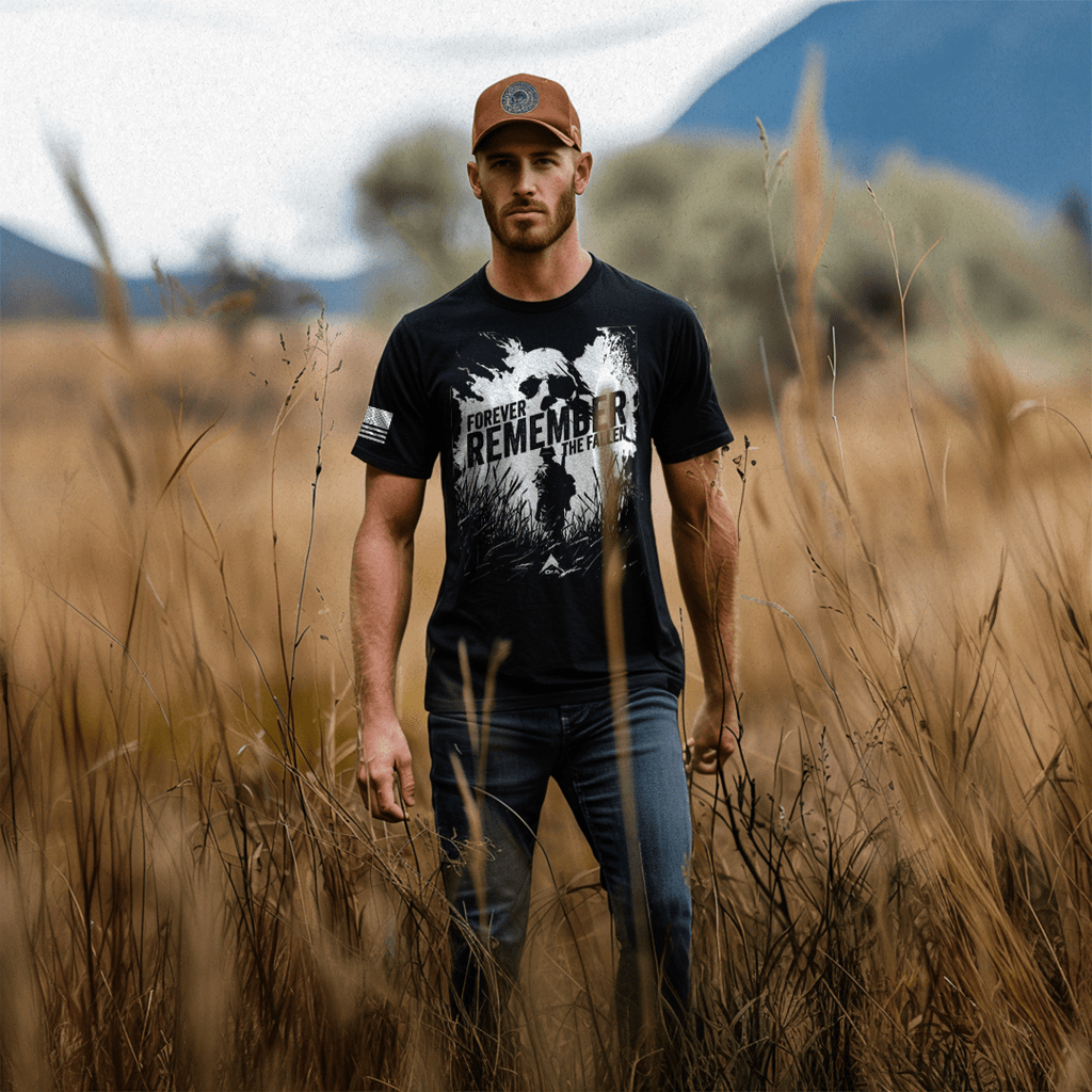 Man in a golden field wearing a black "Forever Remember the Fallen" shirt, American flag on sleeve.