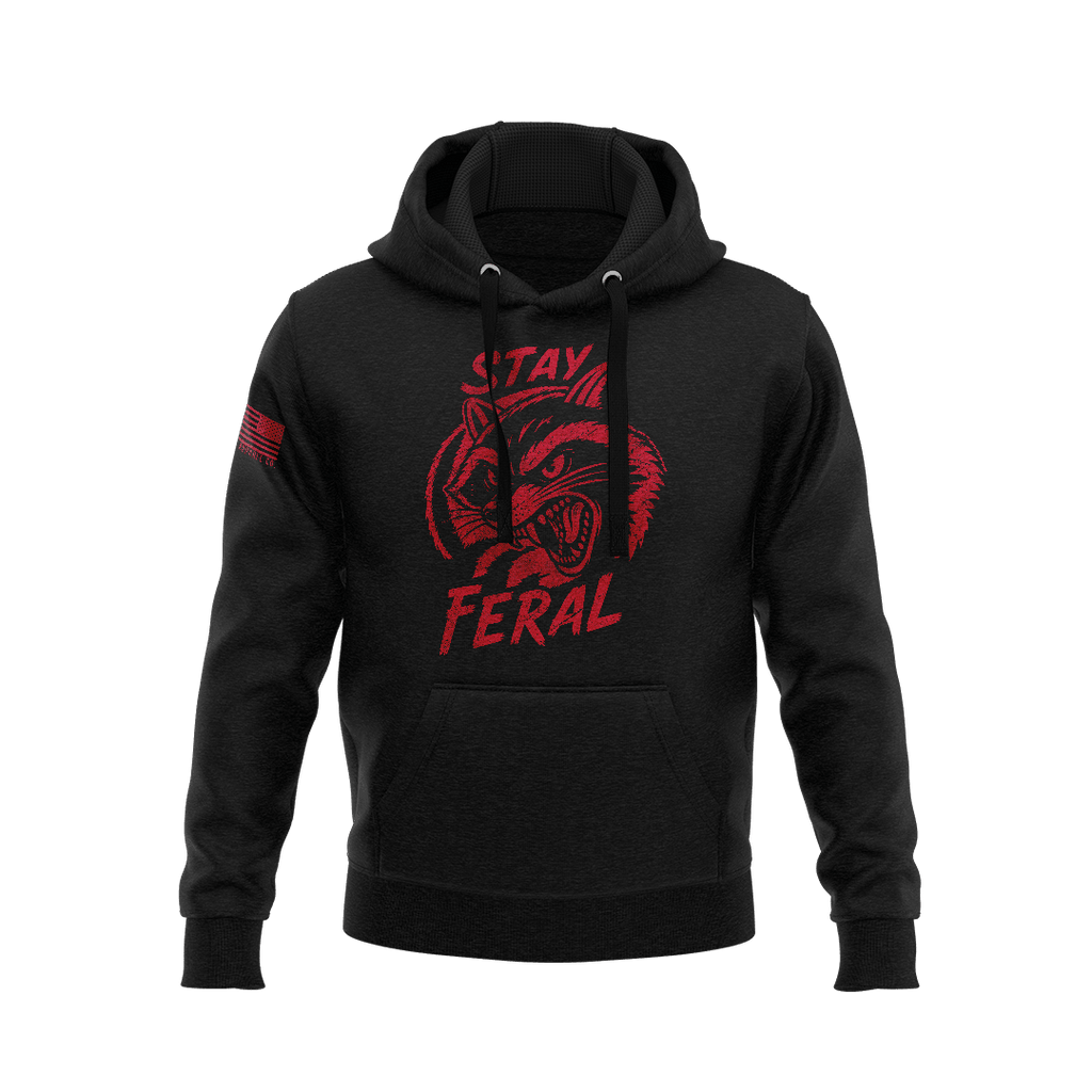Black hoodie featuring red "STAY FERAL" snarling raccoon graphic and an American flag patch on the right sleeve.