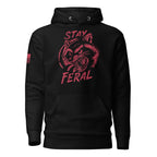 Black hoodie featuring red "STAY FERAL" snarling raccoon graphic and American flag sleeve patch.