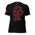 Black t-shirt with distressed red "Stay Feral" snarling raccoon graphic and an American flag patch on right sleeve.