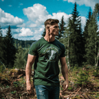 A man in a forest wearing a heather forest wolf graphic t-shirt with "No Excuses. No Regrets" text.