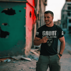 Man standing in an urban setting wearing a black "GRUNT" t-shirt with a skull and "No Skills, Just Kills" graphic.
