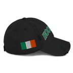 Black distressed baseball cap viewed from right side, featuring green "HOOLIGAN" text and an Irish flag.