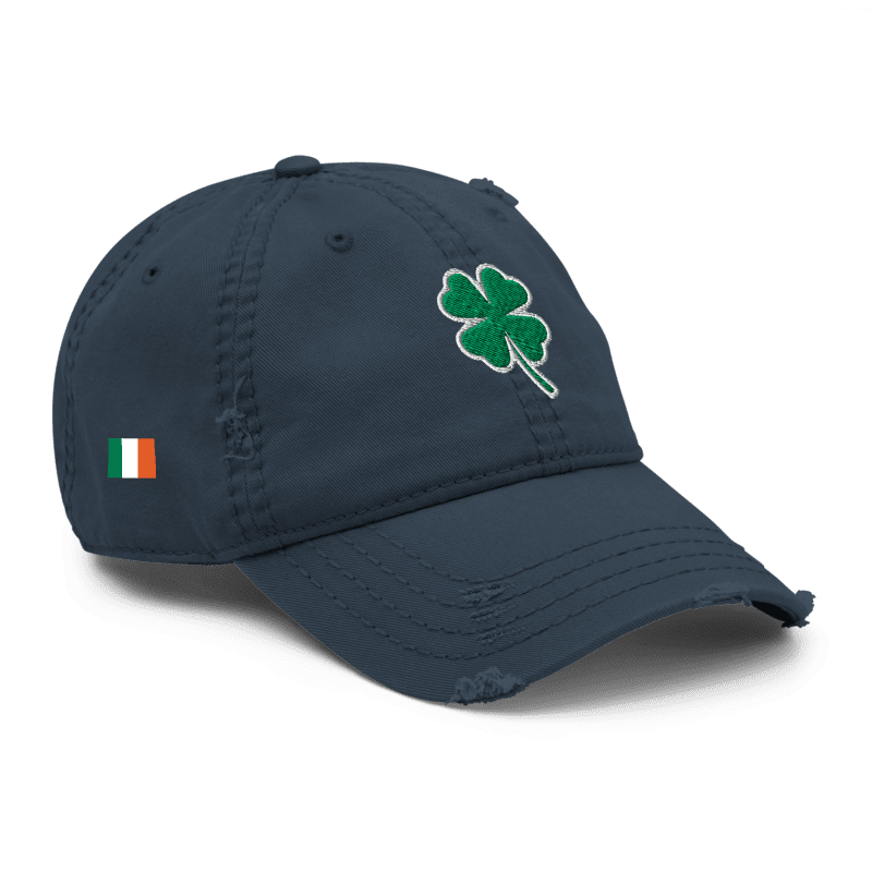 Navy blue distressed cap, angled left, featuring a green shamrock and Irish flag on the side.