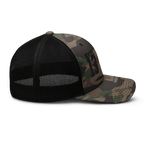 Black/Camo Abbey Gate Trucker Hat shown at a right-side profile highlighting patch embroidery and stitching