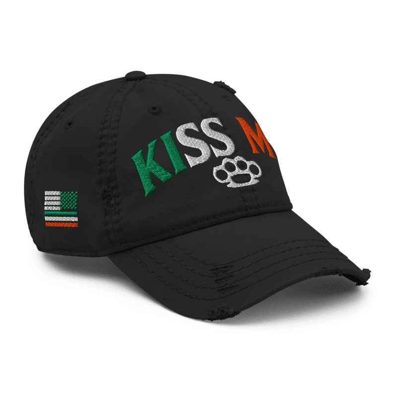 Black distressed ball cap, angled left, with "KISS ME" text and an Irish-American flag graphic on the side.
