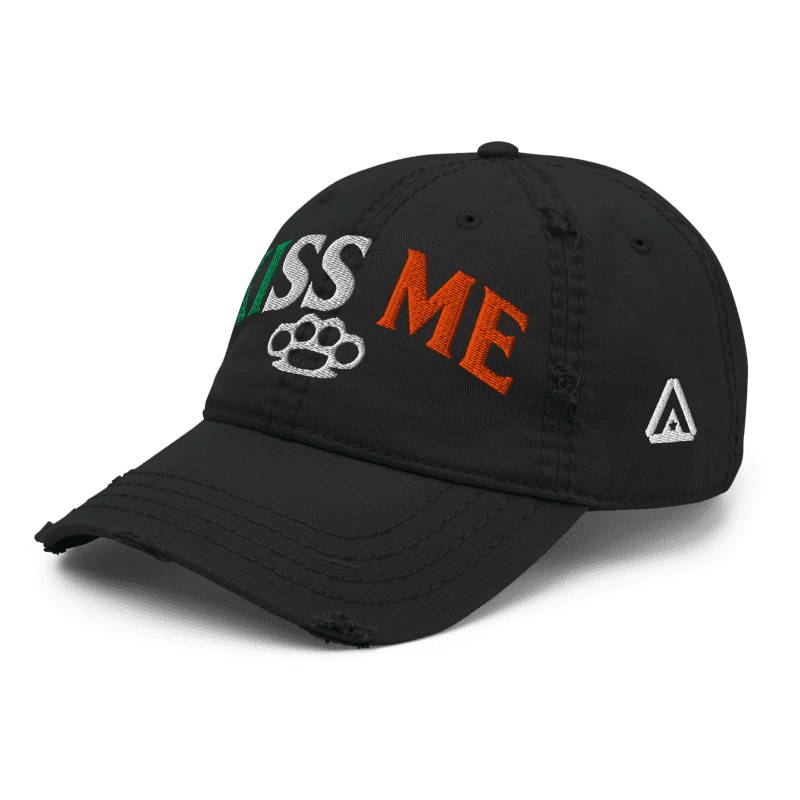 Black distressed ball cap, three-quarter view angled right, with "KISS ME" in Irish flag colors and a small white DIA logo.