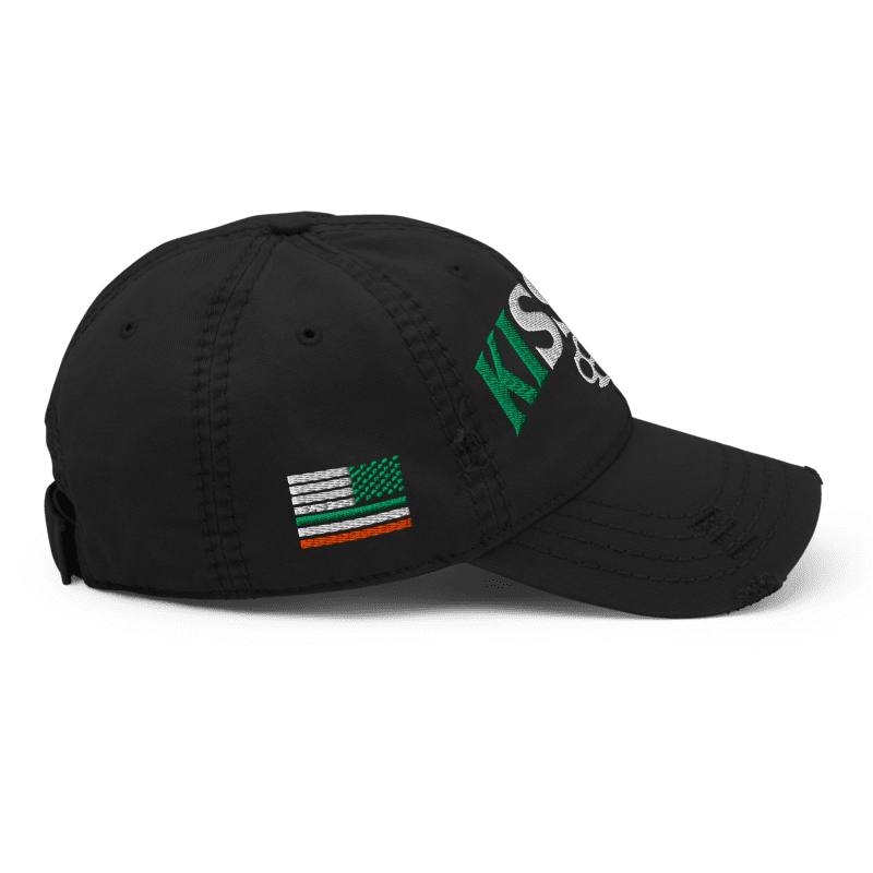 Black distressed ball cap, right-side view, with "KISS ME" text and Irish-American flag graphic on the crown.