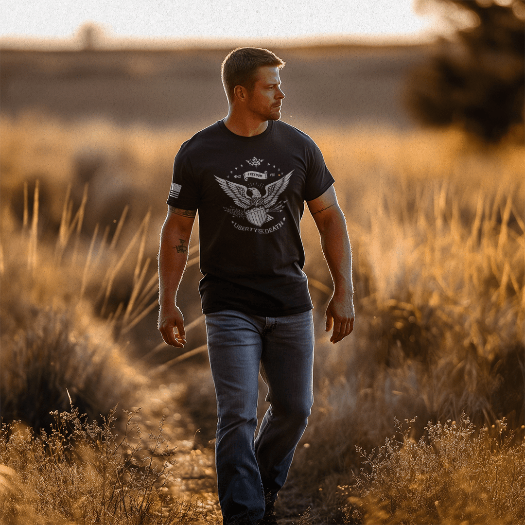 A man walks through a sunlit field wearing a black Liberty or Death t-shirt with a white DIA logo.