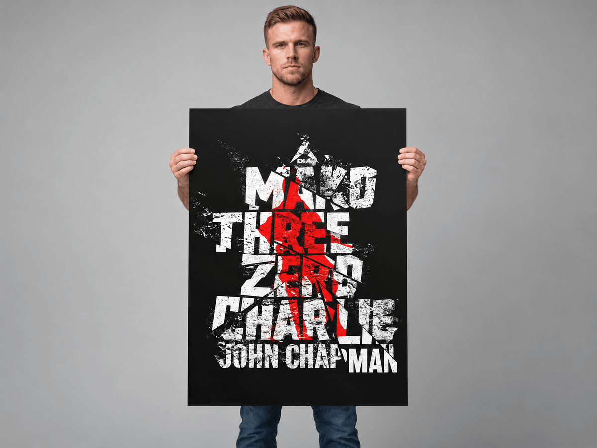 Man in studio holding a large "Mako Three Zero Charlie" John Chapman poster in front of him.