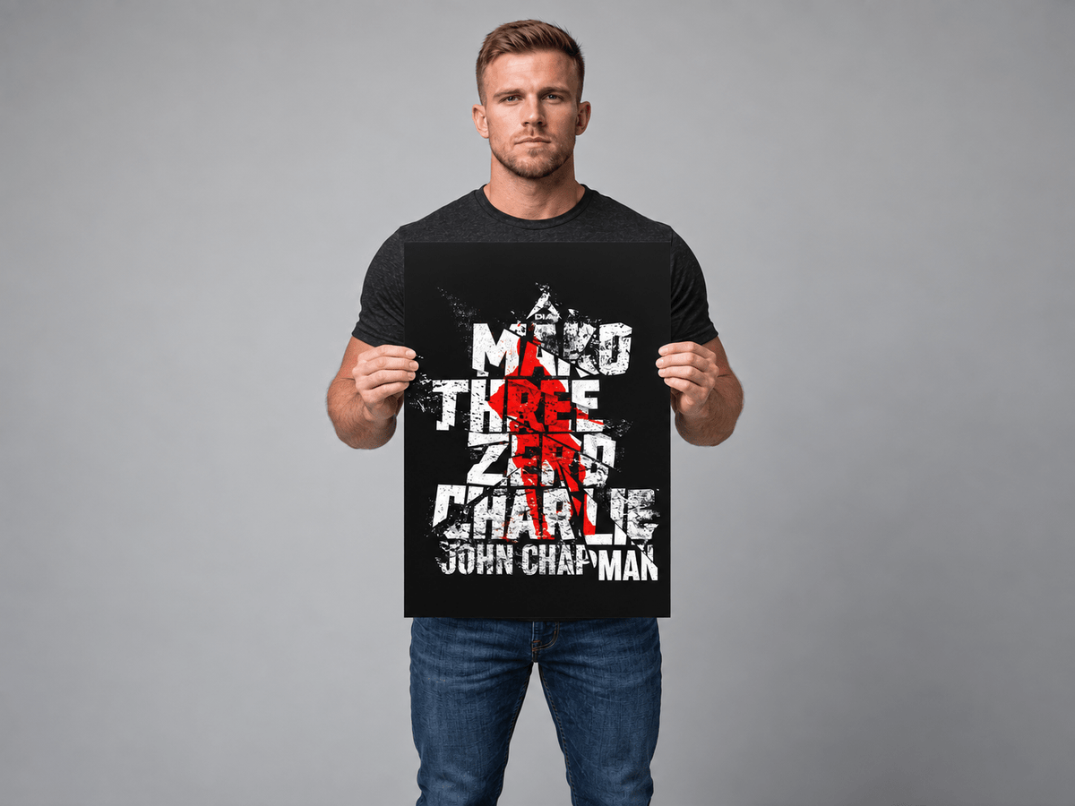 Man in studio holding a medium "Mako Three Zero Charlie" John Chapman memorial poster.