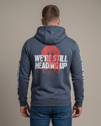 Man facing away in studio wearing navy blue 3 Truck "We're Still Heading Up" FDNY hoodie and jeans.