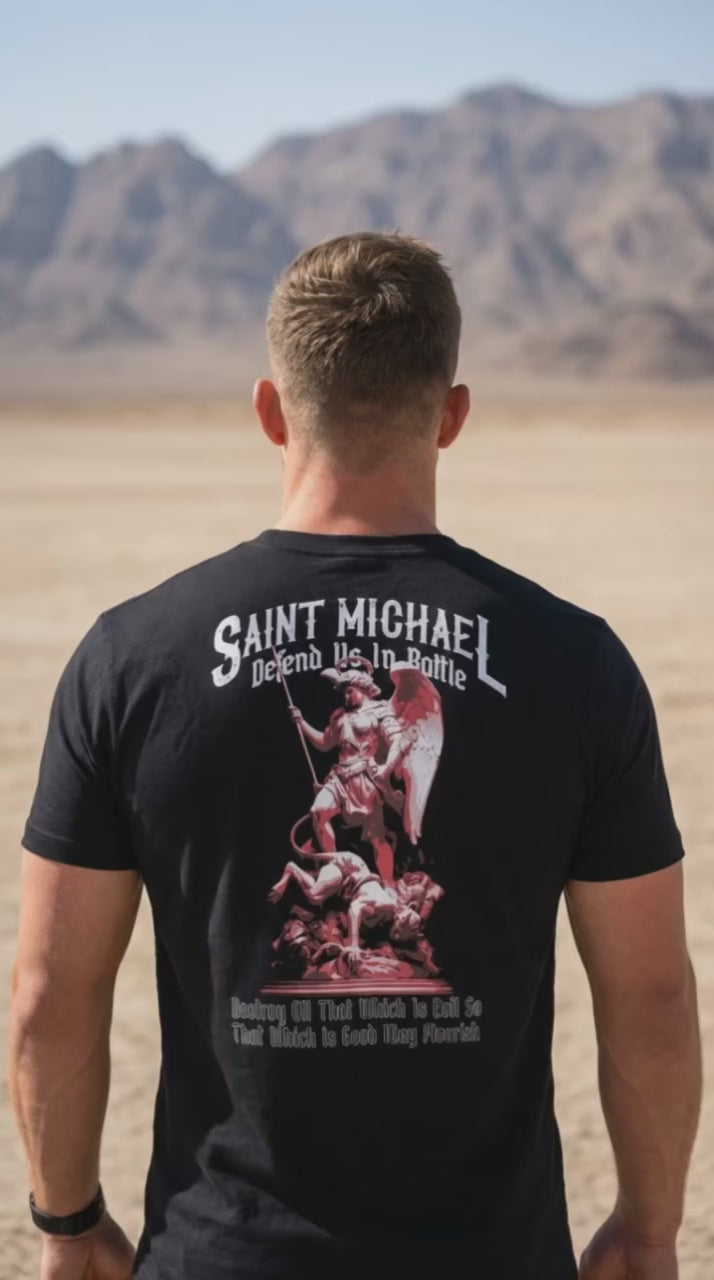 Man, desert setting, black t-shirt with a back graphic of Saint Michael and "Defend Us In Battle" text.