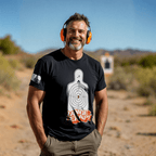Man in desert with ear protection wearing a black Range Therapy t-shirt featuring a silhouette target graphic.