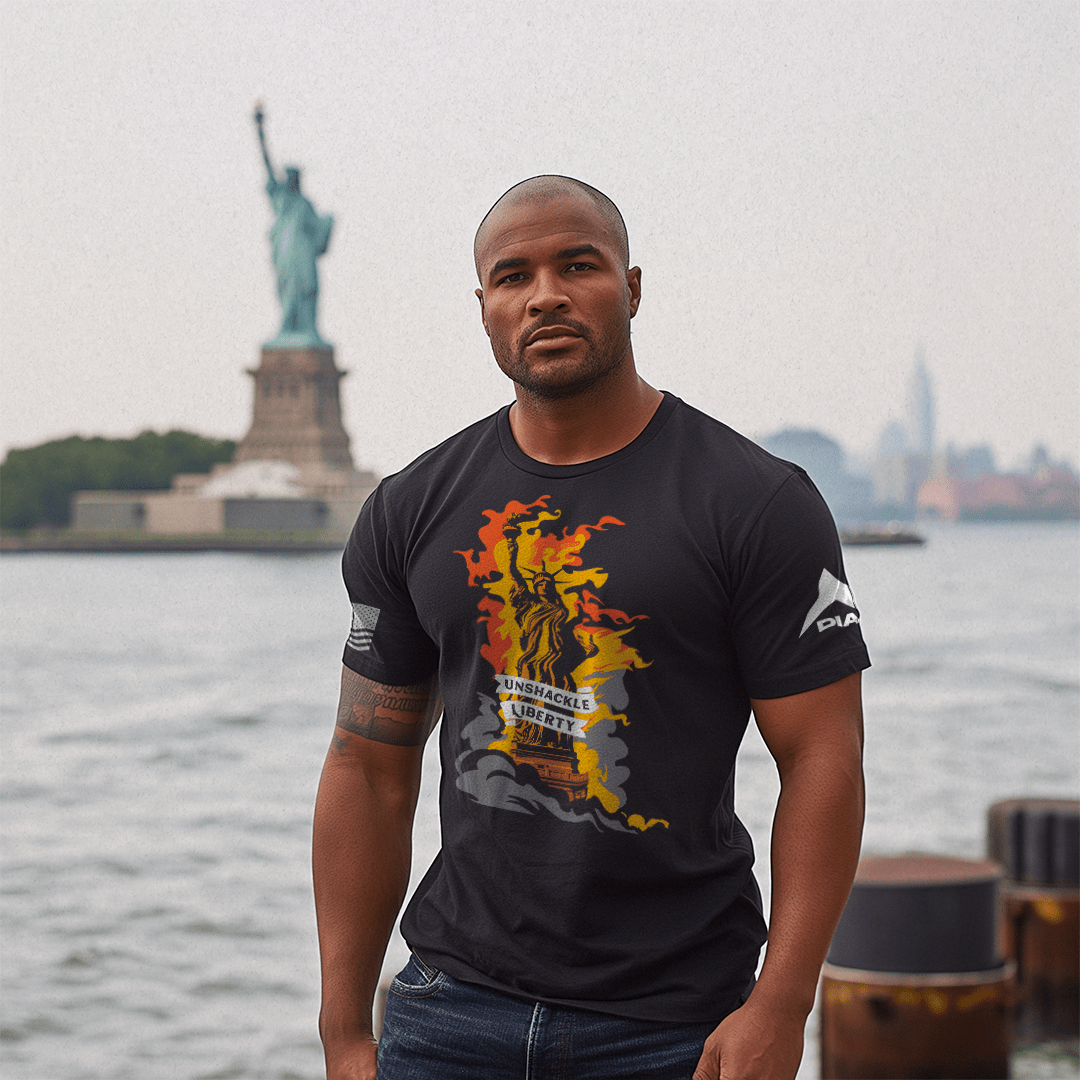 Muscular man by water wearing a black Unshackle Liberty t-shirt with flaming statue and white sleeve flags.