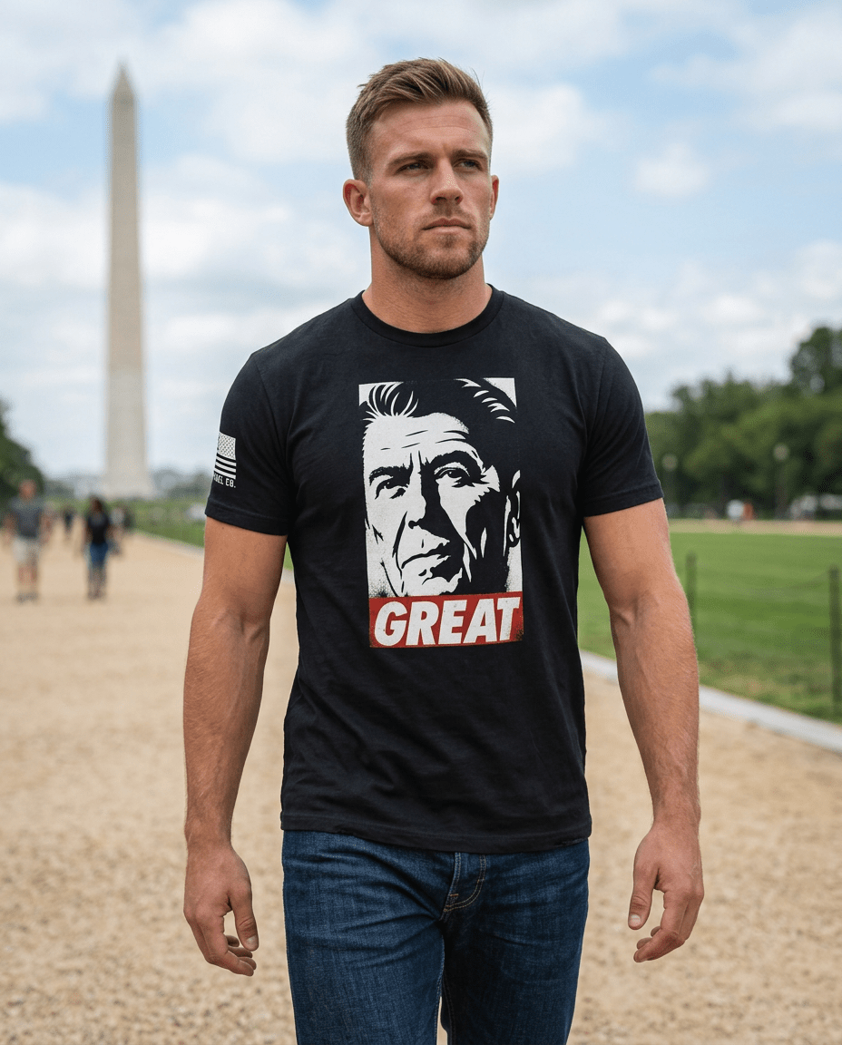 Man walking near the Washington Monument wearing a black T-shirt with a Ronald Reagan "GREAT" graphic.