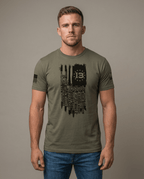 Man in studio wearing olive green t-shirt with Kabul 13 flag graphic listing fallen service members' names.
