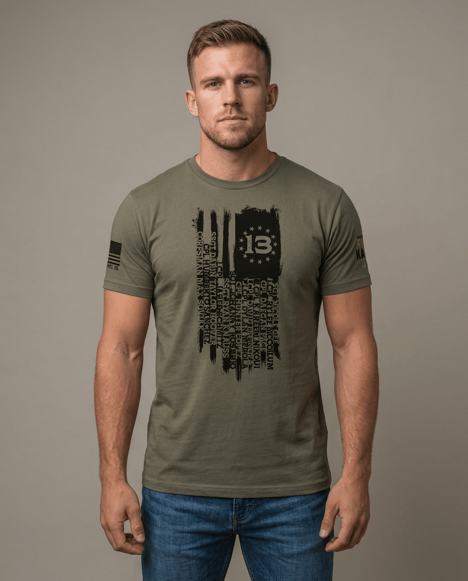 Man in studio wearing olive green t-shirt with Kabul 13 flag graphic listing fallen service members' names.