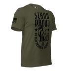 Green shirt angled left, STAND PROUD lion graphic, NEVER HERDED text, DIA logo, and American flag on sleeve.