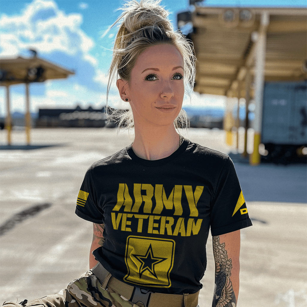 A woman in an outdoor lot wearing a black "ARMY VETERAN" t-shirt with a star emblem and DIA logo on the left sleeve.
