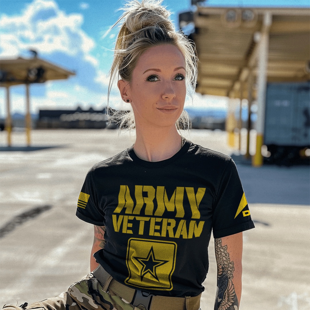 A woman in an outdoor lot wearing a black "ARMY VETERAN" t-shirt with a star emblem and DIA logo on the left sleeve.