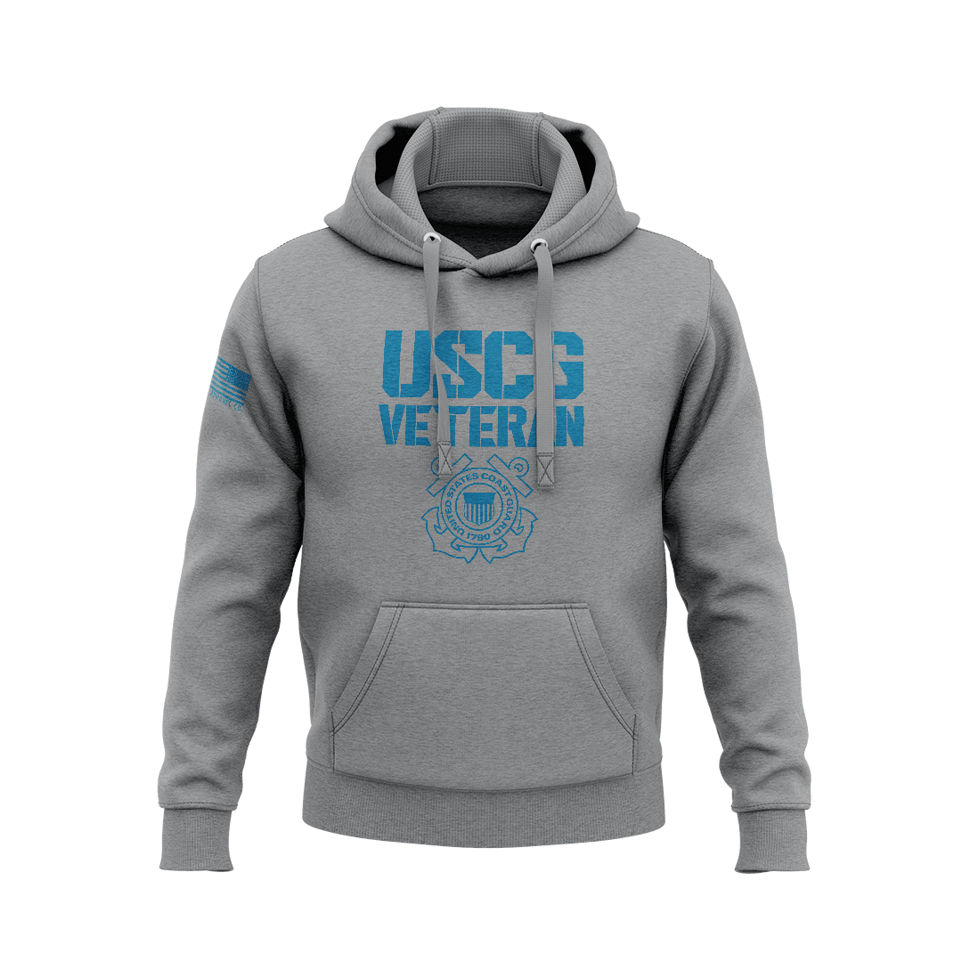 Heather gray hoodie displaying blue "USCG VETERAN" stencil font above Coast Guard seal, with right sleeve flag patch.   