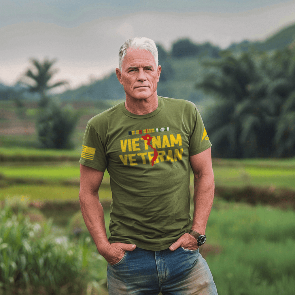 A man stands in a field wearing an army green Vietnam Veteran t-shirt with a yellow American flag and DIA logo on the sleeve.