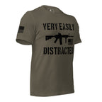Army green shirt angled left featuring a black "VERY EASILY DISTRACTED" rifle graphic and a black American flag.