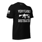 Black shirt angled left featuring a white "VERY EASILY DISTRACTED" rifle graphic and a white sleeve flag.